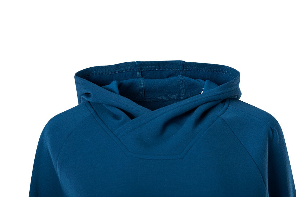 Close-up of a teal cotton hoodie showcasing its soft texture, double stitching, and raglan sleeves
