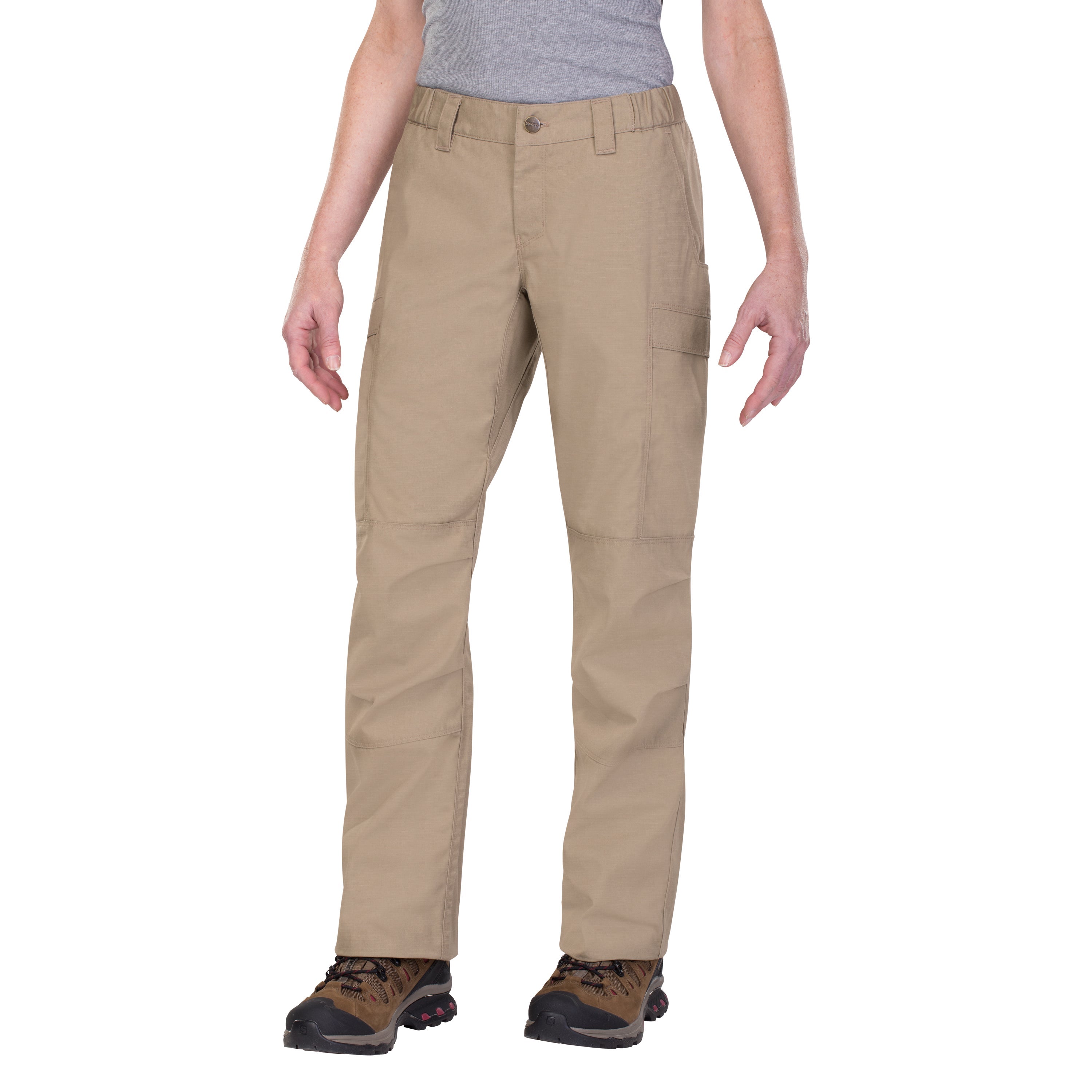 Product shot of tan women's tactical pants featuring multiple pockets and a button fly worn with brown hiking boots against a white background
