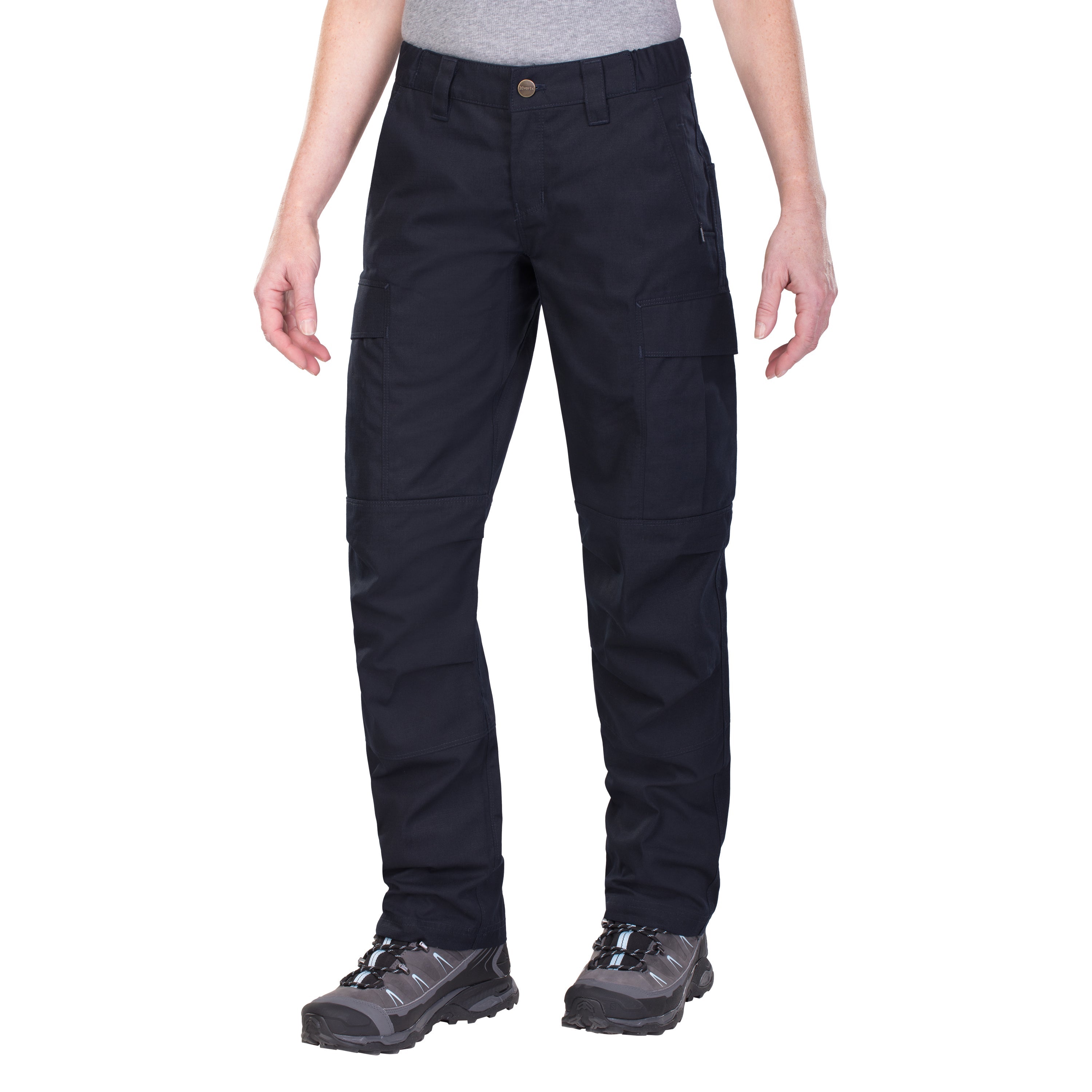 Product shot of a pair of dark navy blue women's cargo pants featuring multiple pockets and a brass button a model is wearing gray hiking boots with light blue accents against a white background