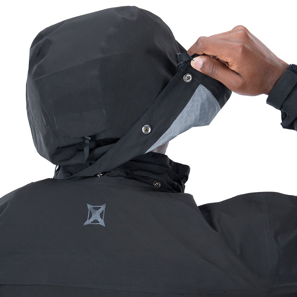 Product shot showing a person adjusting the black waterproof hooded jacket with grey inner lining and snap buttons featuring a unique logo on the back