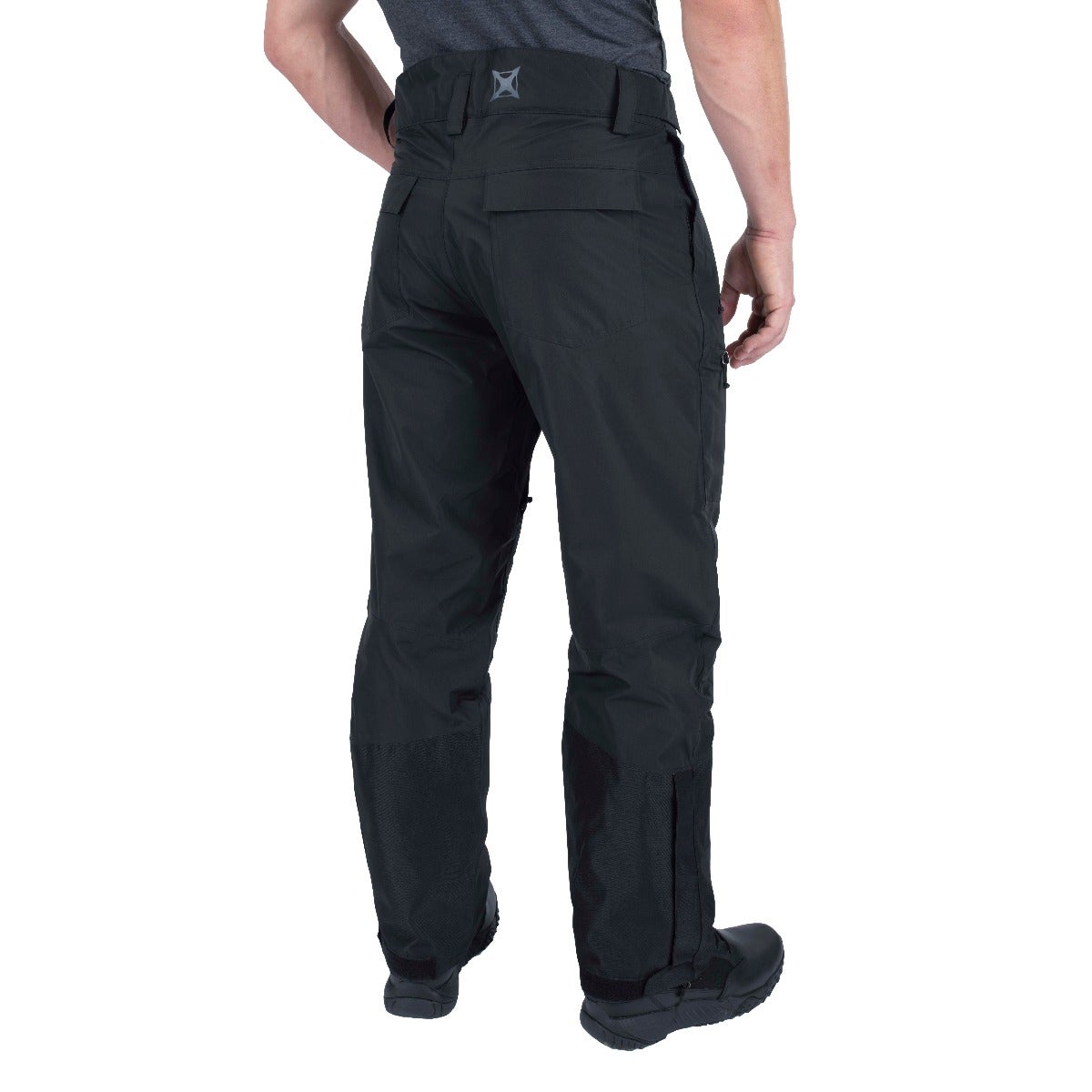 Product shot showing black men's snow pants with reinforced lower legs and zippered gaiters featuring a gray logo on the back waistband against a white background