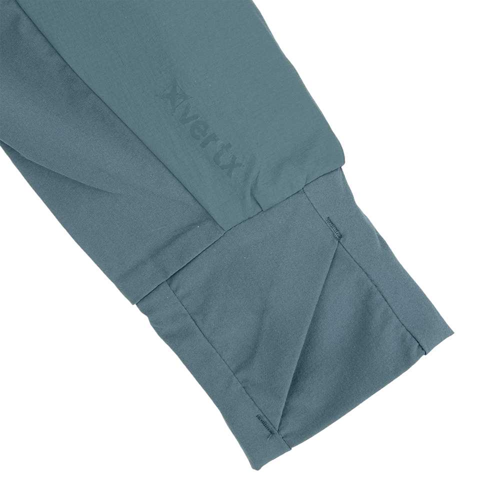 Close-up detail of a teal Arc'teryx garment showing its textured fabric, subtle stitching, and embossed logo