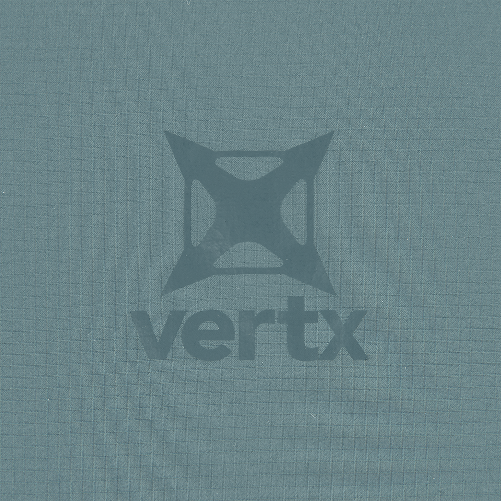 Vertrx logo on a textured teal fabric featuring a geometric design with subtle shading and a slightly distressed appearance