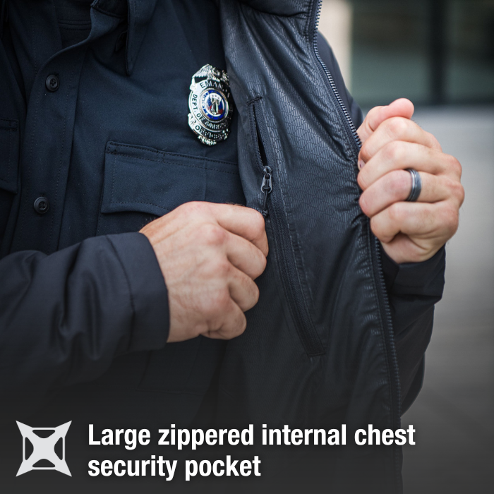 Photograph showing a close-up of a person's hands opening a large zippered internal chest pocket on a dark jacket, featuring a police badge with an eagle and American flag, and a textured fabric with subtle diamond patterning and a dark gray background